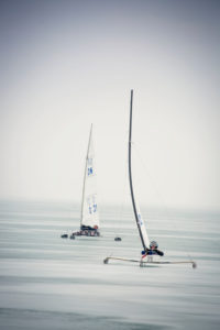 Ice sailing European championship on Lake Balaton in Hungary, Two ice sailors high on the wind on their way to the turning point Ice sailing European championship on Lake Balaton in Hungary, Two ice sailors high on the wind on their way to the turning point